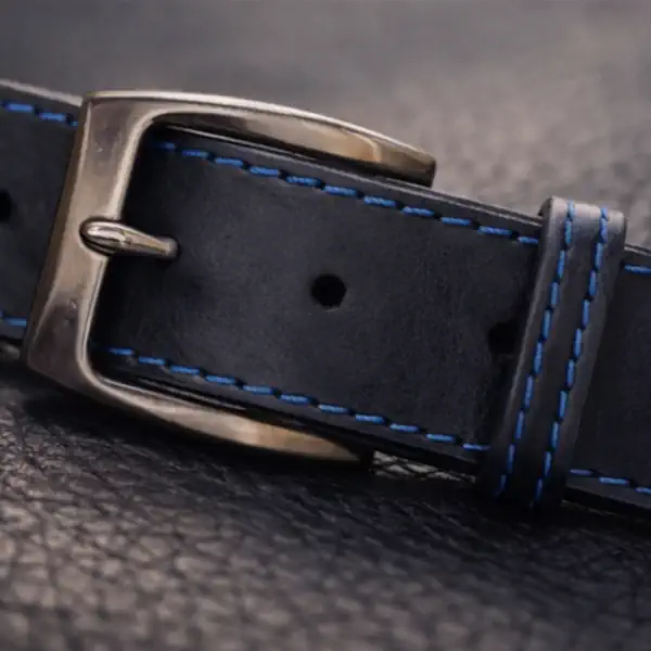 Ceinture en cuir noir, teintée bleu marine, avec piqure décorative bleu. Fabrication artisanale dans notre atelier en Vendée, France. Ici, la boucle.
