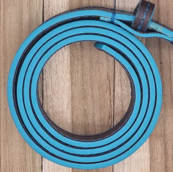 Ceinture en cuir marron avec une piqure bleu et les tranches teintées en bleu turquoise. Boucle de forme carrée, couleur canon de fusil.