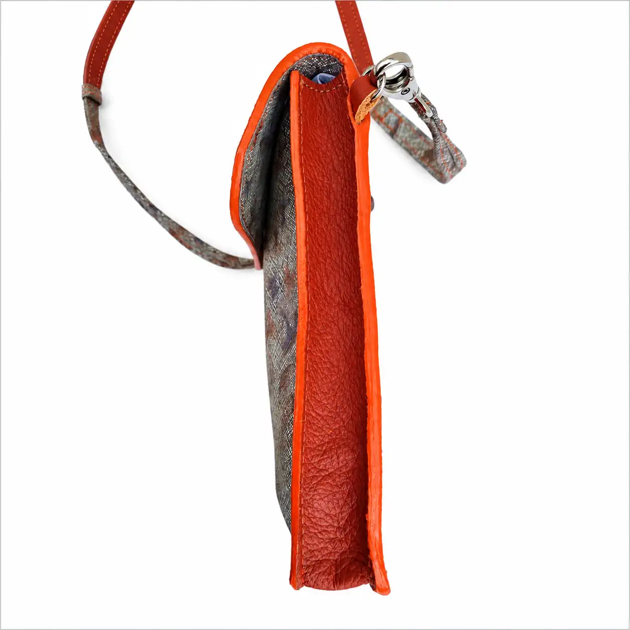 Pochette artisanale en cuir orange brique motif papillons, portée en bandoulière, fabrication française. (Tranche)