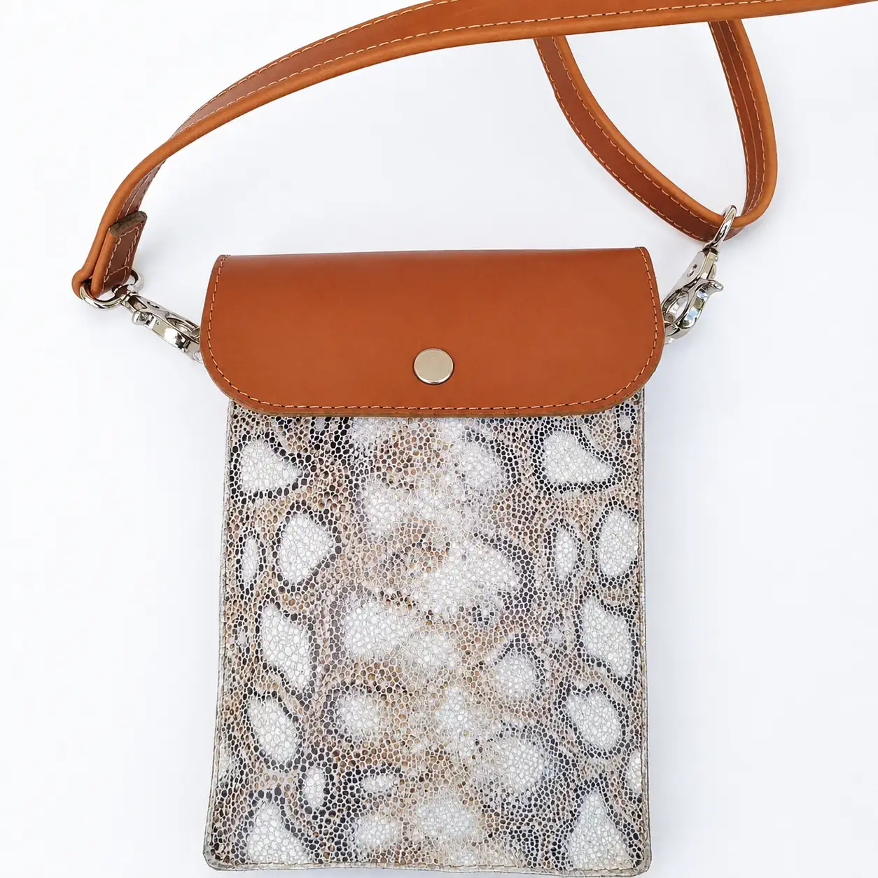 Pochette artisanale en cuir camel et beige à motifs jungle, avec bandoulière.