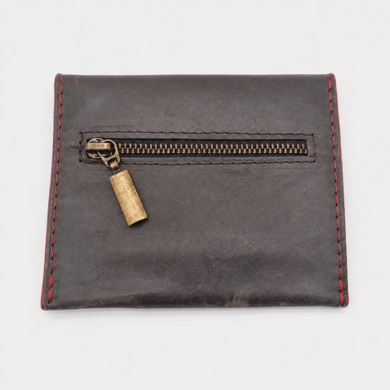Dos d'un porte-monnaie artisanal en cuir gris foncé avec poche zippée extérieure