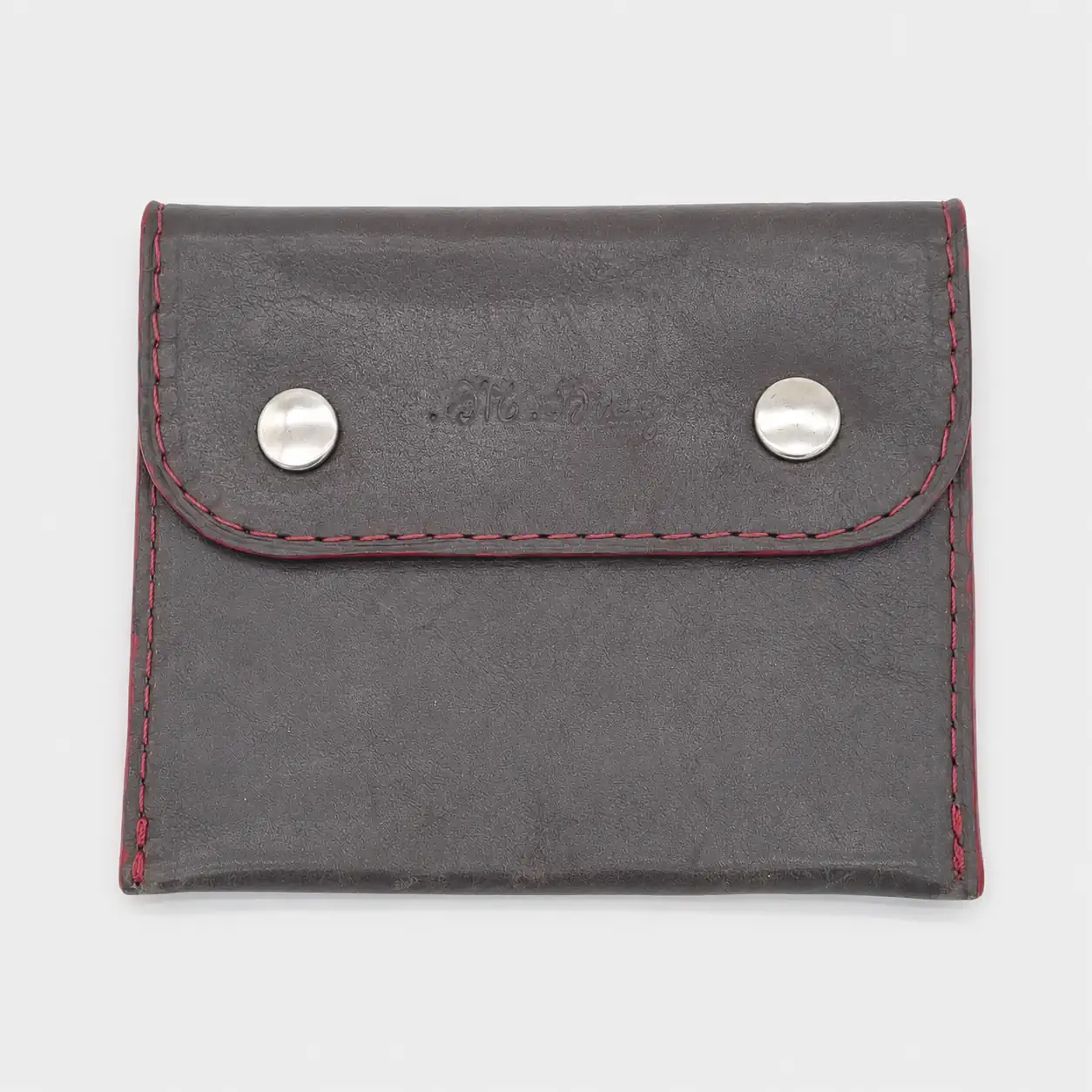 Porte-monnaie artisanal en cuir de veau gris foncé et agneau rouge avec rabat double pressions.