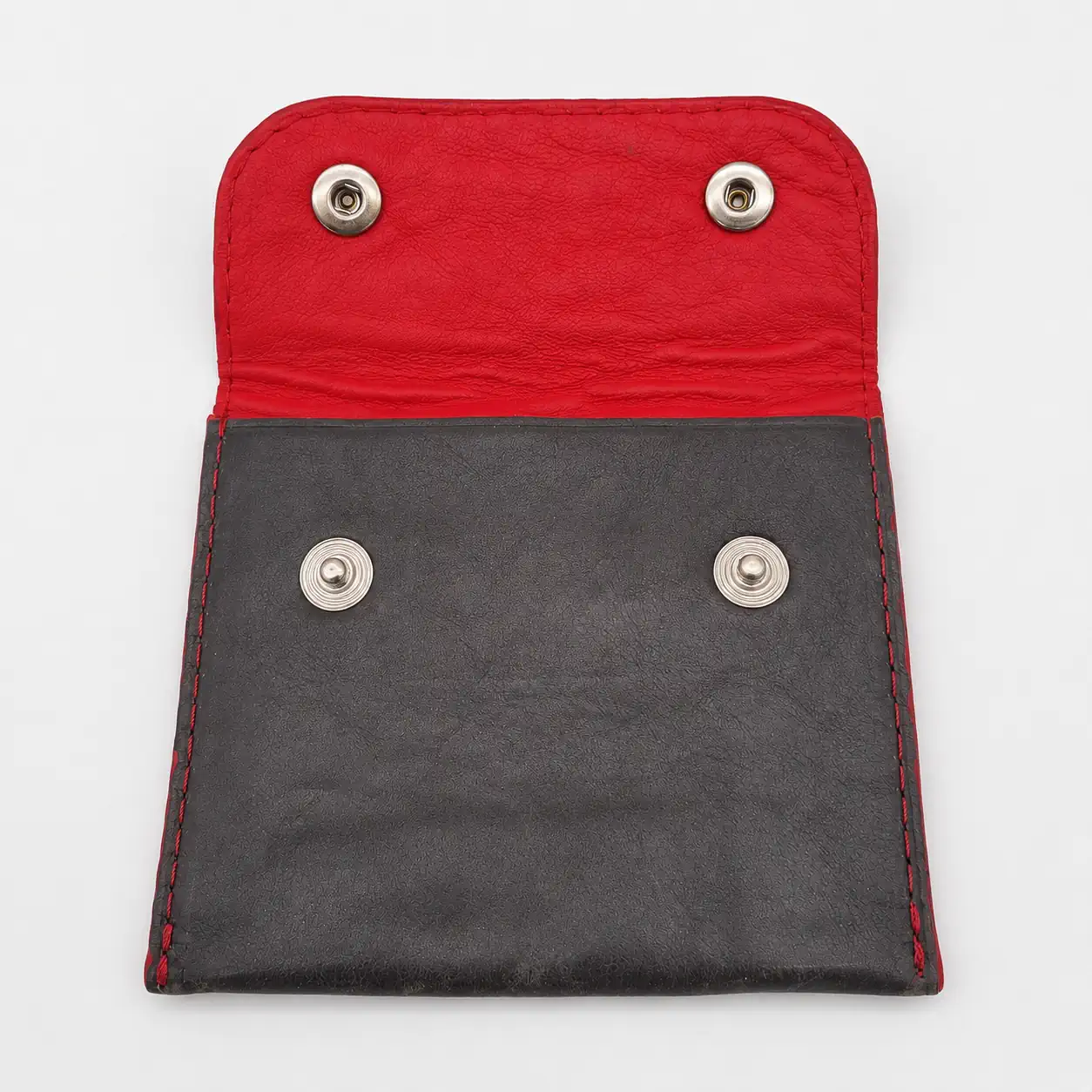 Intérieur en cuir d'agneau rouge d'un porte-monnaie artisanal en cuir gris foncé