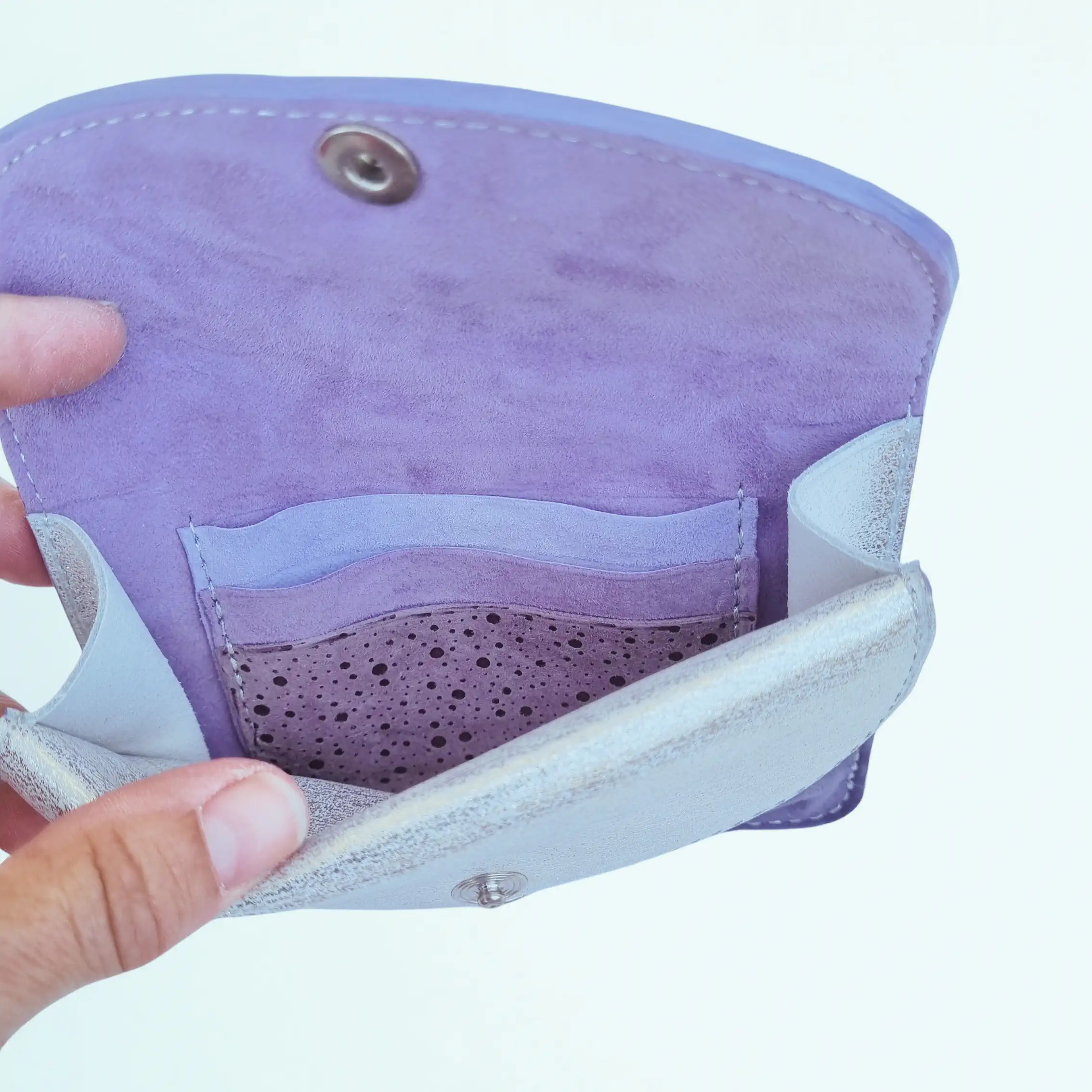 Portefeuille femme en cuir à rabats format moyen. Intérieur violet et parme en cuir de chèvre, avec poche plaquée et compartiments pour cartes. Vue intérieure.