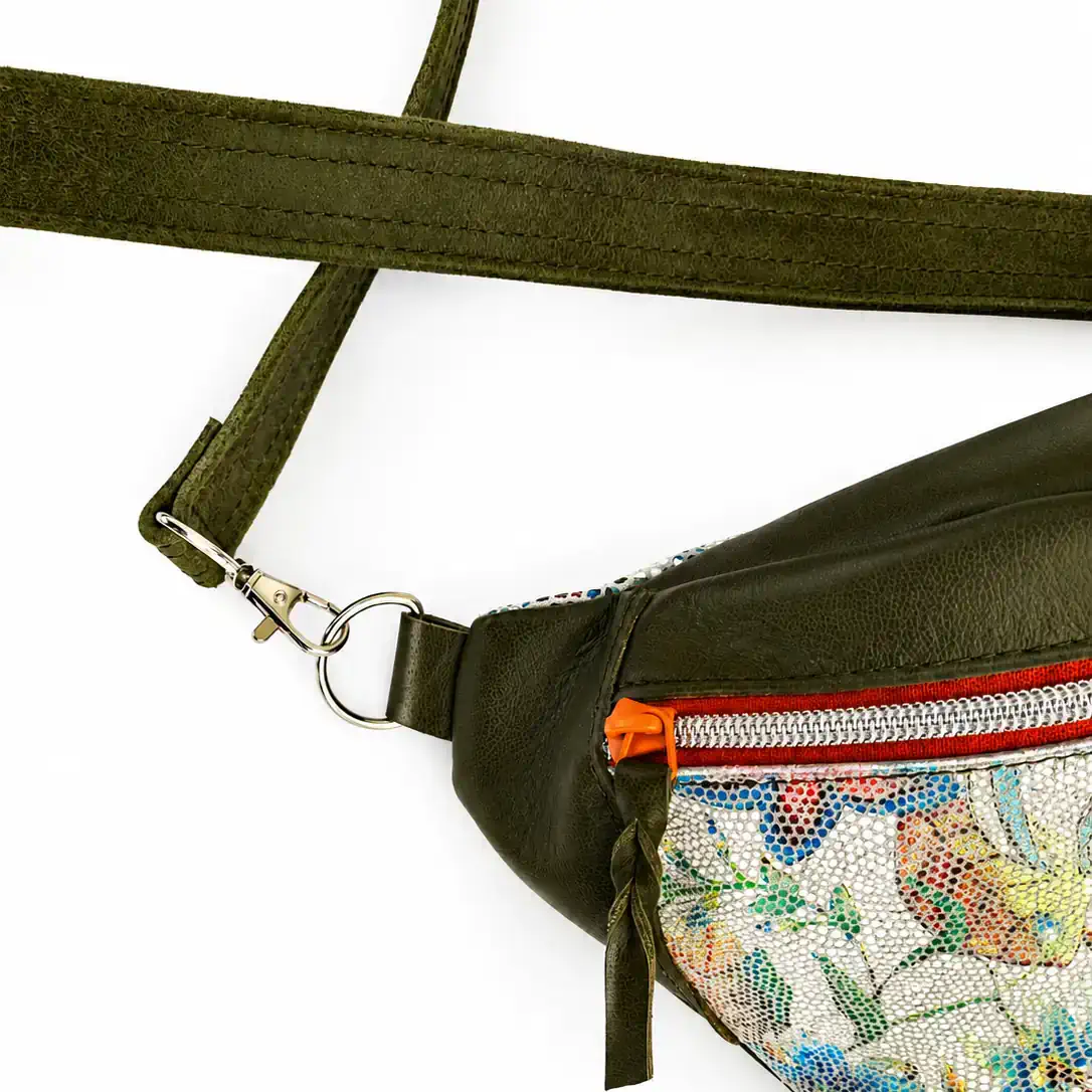 Détail de l'attache métallique de la bandoulière en cuir du sac banane